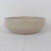 Sandstone beige speckled stoneware serving bowl with deep rounded shape and minimalist design
